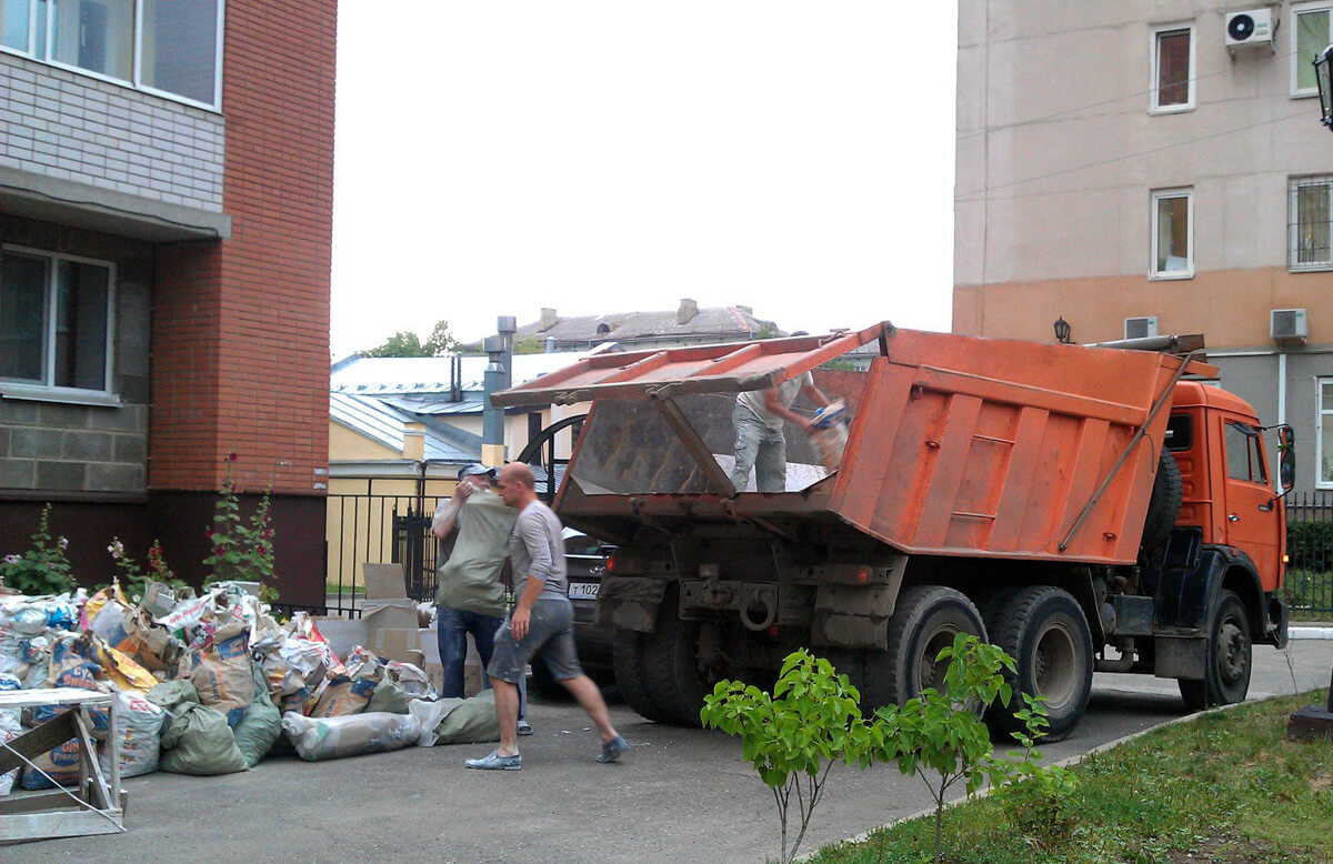 Загрузка грузового транспорта мусором грузчиками